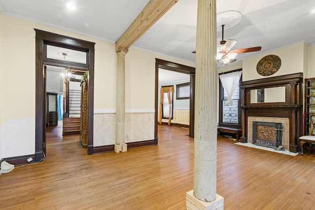 interior space with ceiling fan, light wood-type flooring, crown molding, and decorative columns