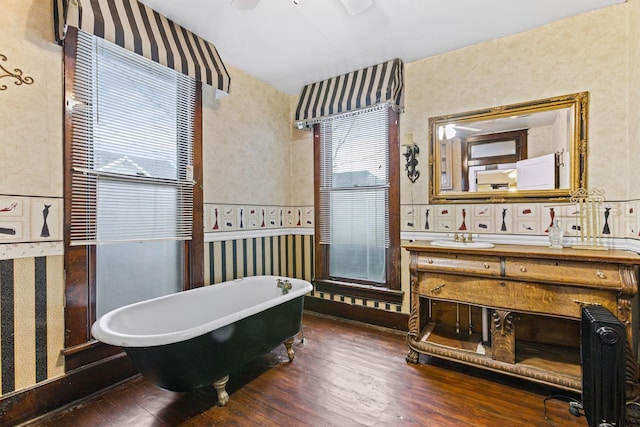 bathroom with hardwood / wood-style flooring, vanity, a bathing tub, and ceiling fan