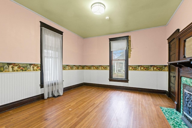 empty room with ornamental molding and light hardwood / wood-style flooring