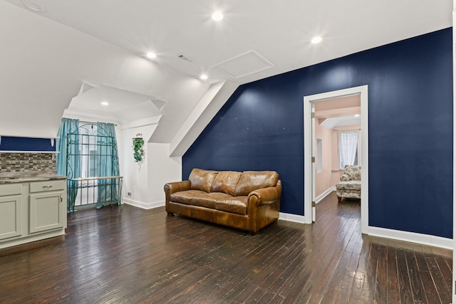 living area with vaulted ceiling, a wealth of natural light, and hardwood / wood-style floors