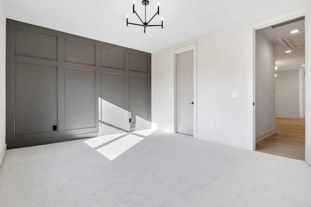 unfurnished bedroom featuring light colored carpet and a notable chandelier