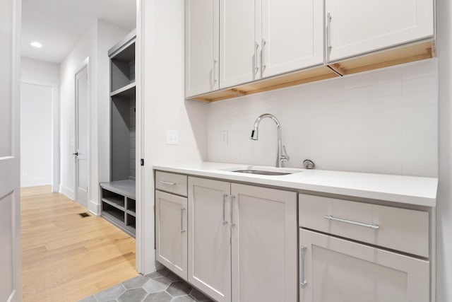 kitchen with sink, white cabinetry, and light hardwood / wood-style flooring