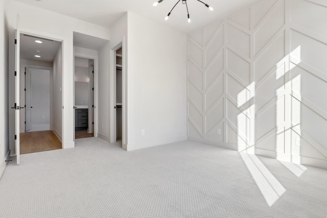 carpeted spare room featuring a notable chandelier