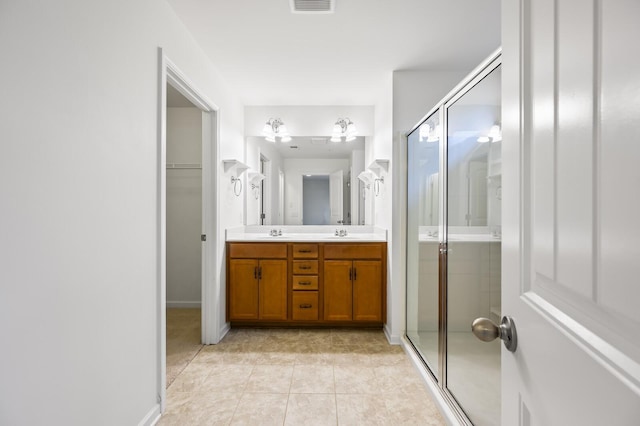 bathroom featuring vanity, tile patterned flooring, and a shower with door