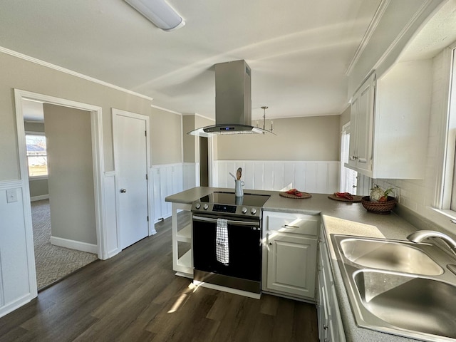 kitchen with sink, crown molding, stainless steel range with electric stovetop, white cabinets, and island range hood