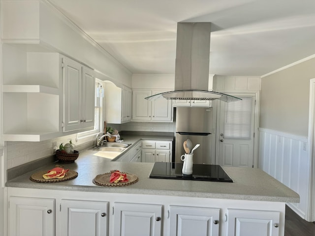 kitchen with black electric cooktop, island range hood, a sink, freestanding refrigerator, and open shelves