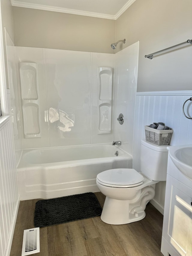 full bath featuring shower / washtub combination, a wainscoted wall, visible vents, toilet, and wood finished floors