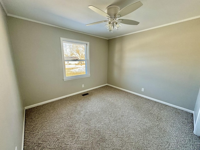 spare room with crown molding, visible vents, a ceiling fan, carpet flooring, and baseboards