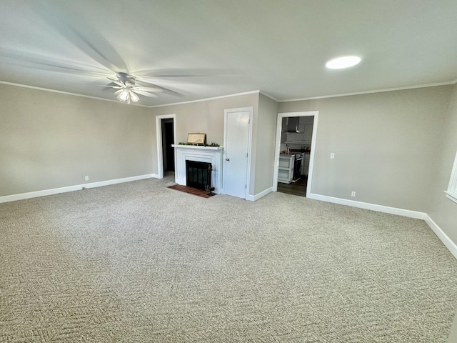 unfurnished living room with a fireplace with flush hearth, crown molding, carpet floors, and baseboards