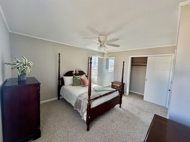 carpeted bedroom featuring ceiling fan, a closet, and crown molding