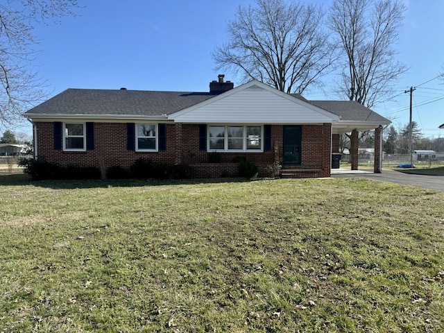 ranch-style house with brick siding, a shingled roof, driveway, a chimney, and a front yard