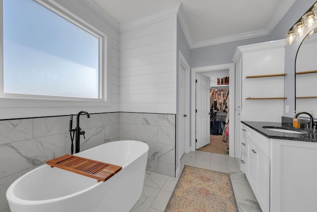 bathroom featuring tile walls, a bathtub, vanity, and ornamental molding