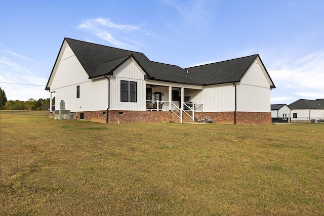 rear view of house with covered porch and a lawn