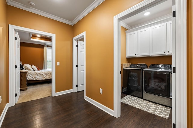 washroom with dark wood-type flooring, washer and clothes dryer, and ornamental molding