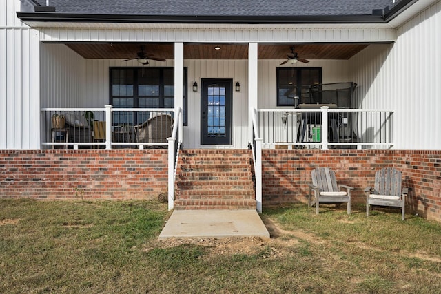 doorway to property with ceiling fan, a yard, and covered porch