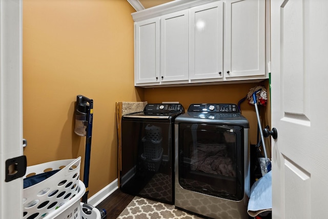 washroom featuring washer and clothes dryer, dark hardwood / wood-style flooring, and cabinets