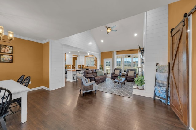 living room with high vaulted ceiling, a barn door, dark wood-type flooring, and ceiling fan with notable chandelier