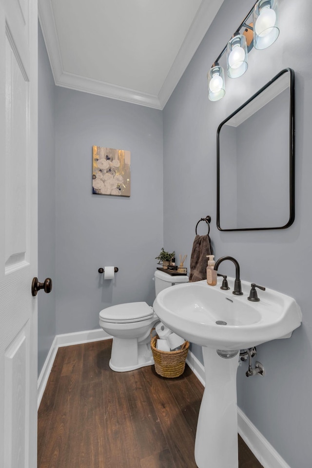 bathroom featuring toilet, crown molding, and hardwood / wood-style flooring