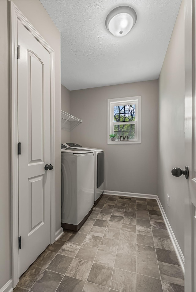 laundry area featuring a textured ceiling and independent washer and dryer