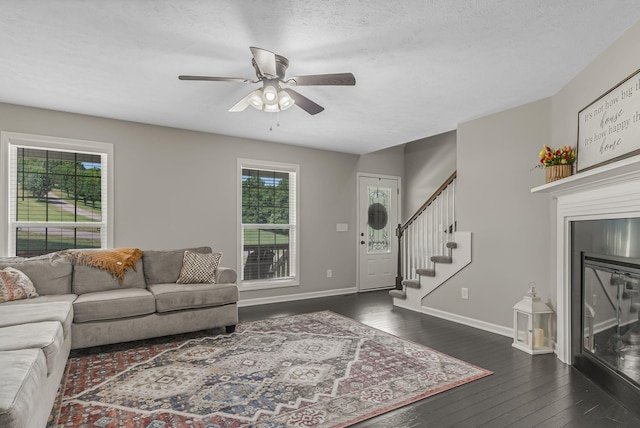 living room with ceiling fan and dark hardwood / wood-style flooring