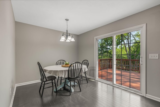 dining area with dark hardwood / wood-style flooring and a chandelier