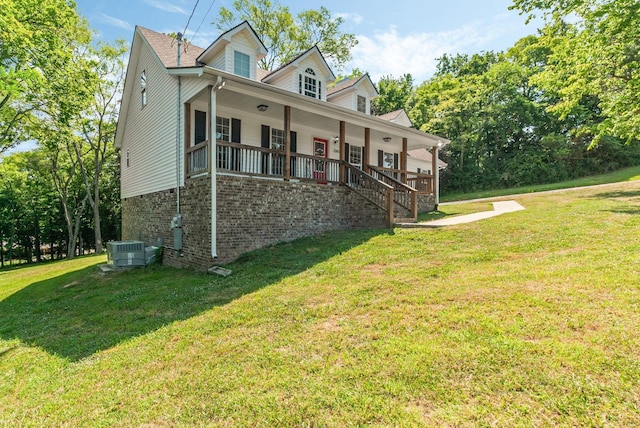 view of front of property with a front yard, a porch, and central AC unit