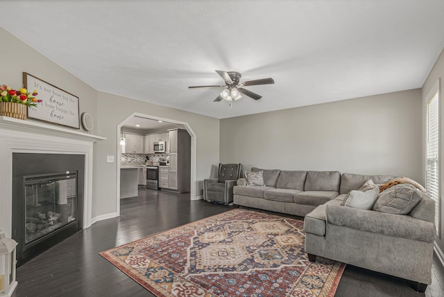 living room with ceiling fan and dark hardwood / wood-style floors