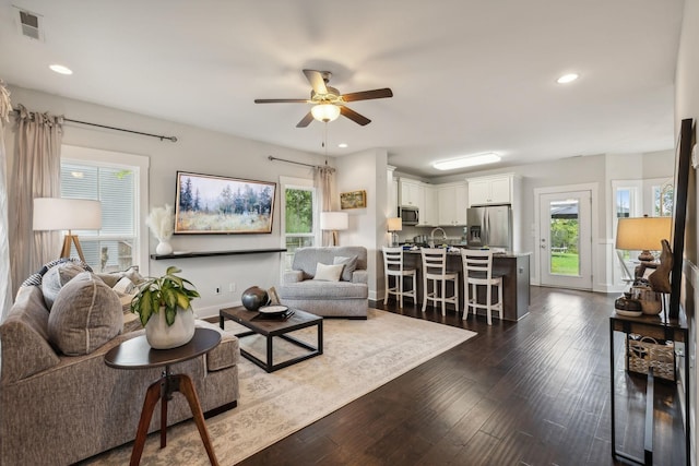 living room featuring ceiling fan and dark hardwood / wood-style flooring