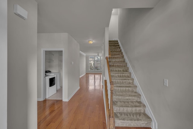 stairs with ceiling fan, wood-type flooring, and washer / clothes dryer