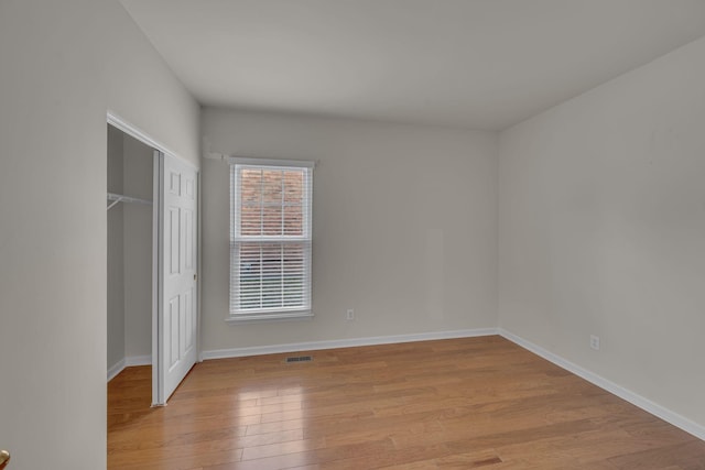 unfurnished bedroom with light wood-type flooring and a closet