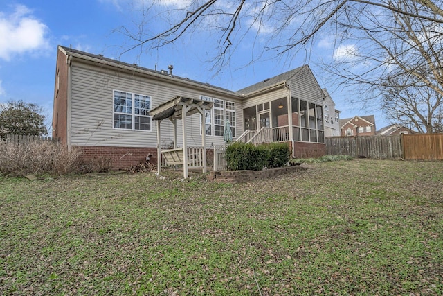 rear view of property with a sunroom and a yard