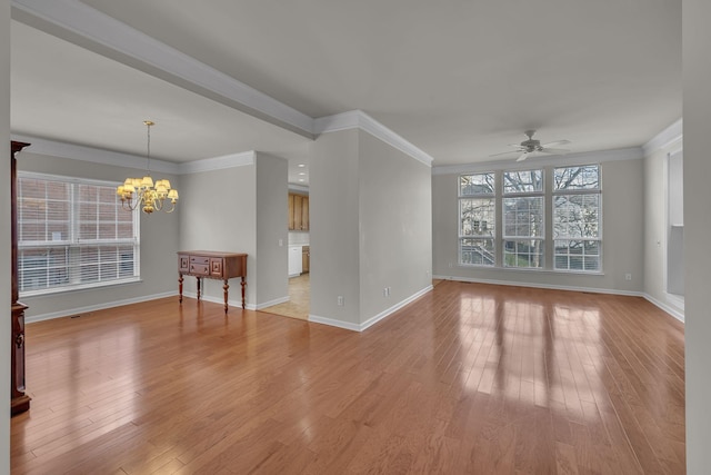 empty room featuring light hardwood / wood-style floors, crown molding, and ceiling fan with notable chandelier