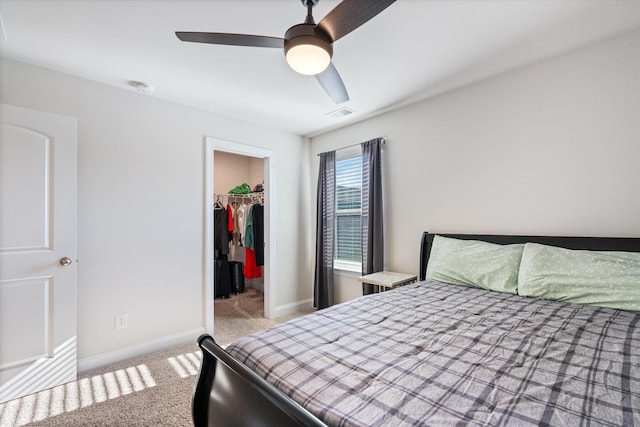 bedroom featuring ceiling fan, light colored carpet, a spacious closet, and a closet