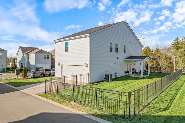 view of property exterior featuring a garage, central air condition unit, and a yard