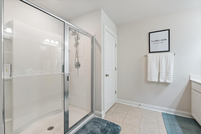 bathroom with tile patterned flooring, a shower with door, and vanity