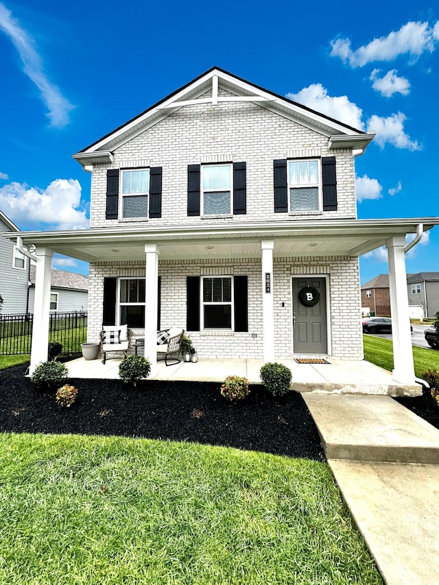 front of property featuring covered porch and a front yard