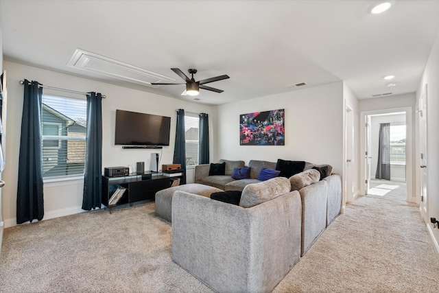 carpeted living room with ceiling fan and plenty of natural light