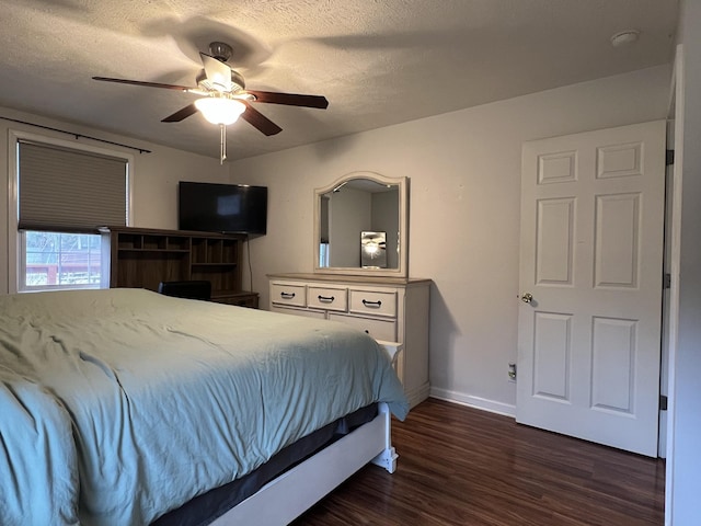 bedroom with ceiling fan, a textured ceiling, and dark hardwood / wood-style floors