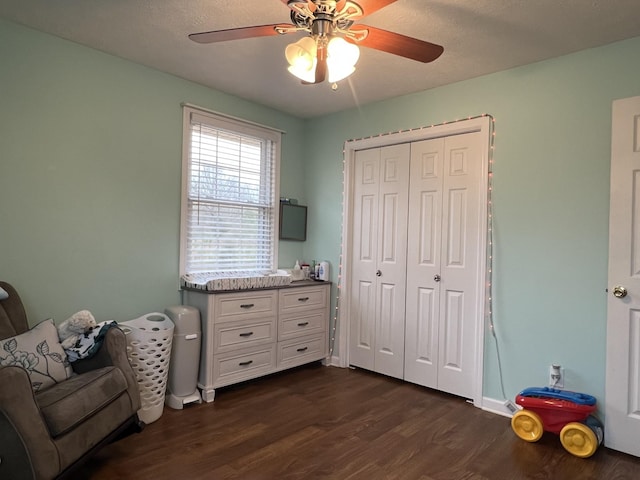 interior space with ceiling fan, a closet, and dark hardwood / wood-style floors