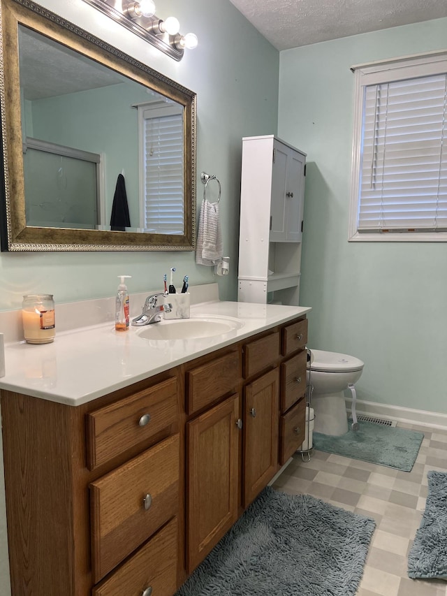 bathroom featuring a textured ceiling, toilet, and vanity