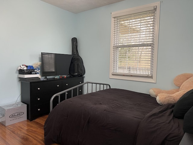 bedroom featuring hardwood / wood-style floors and multiple windows