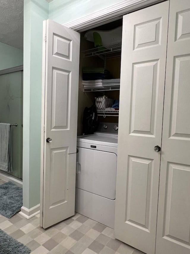 clothes washing area with washer / dryer and a textured ceiling