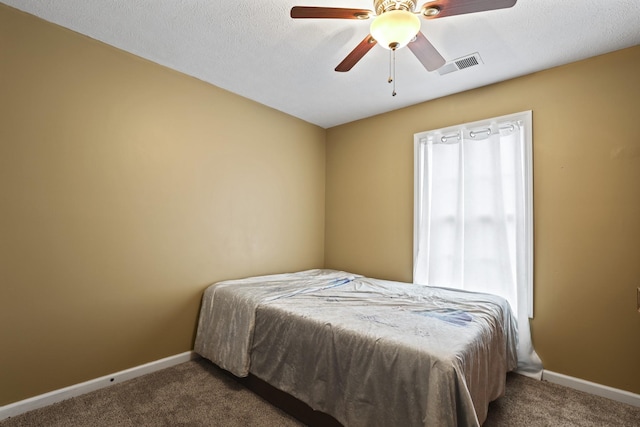 bedroom featuring ceiling fan, multiple windows, and dark carpet