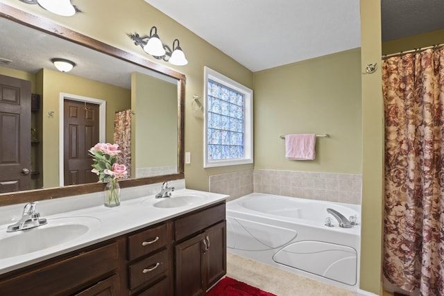 bathroom with vanity, a textured ceiling, tile patterned floors, and a tub