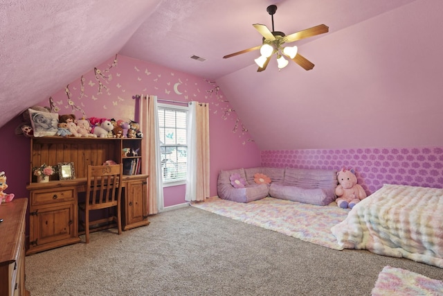 bedroom with ceiling fan, vaulted ceiling, carpet floors, and a textured ceiling