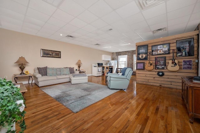 living room featuring a paneled ceiling and hardwood / wood-style flooring