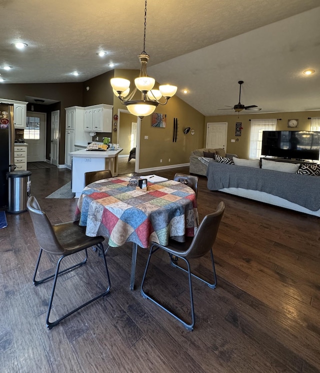 dining space with ceiling fan with notable chandelier, dark wood-type flooring, a textured ceiling, and lofted ceiling