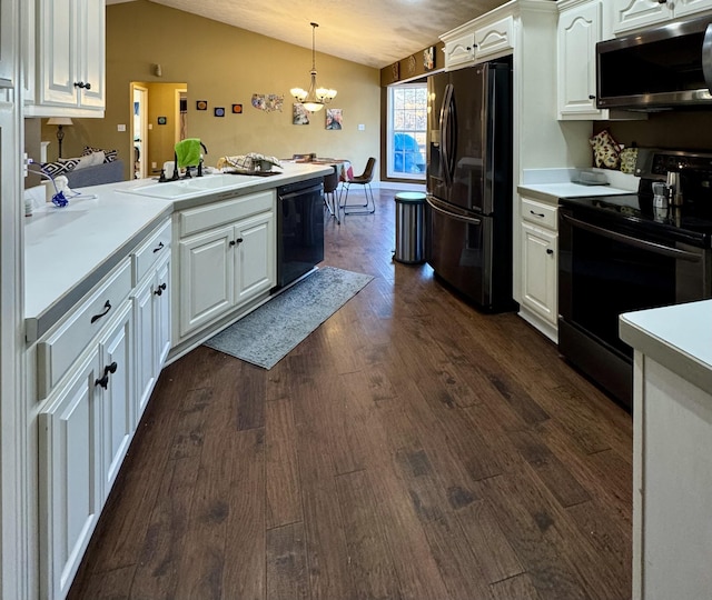 kitchen with white cabinets, black appliances, decorative light fixtures, sink, and vaulted ceiling