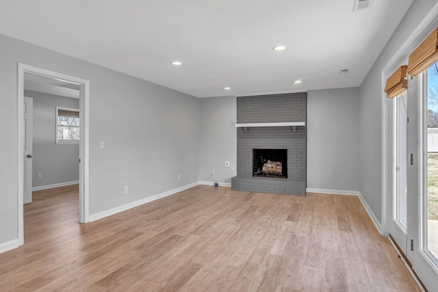 unfurnished living room with a fireplace and light hardwood / wood-style flooring