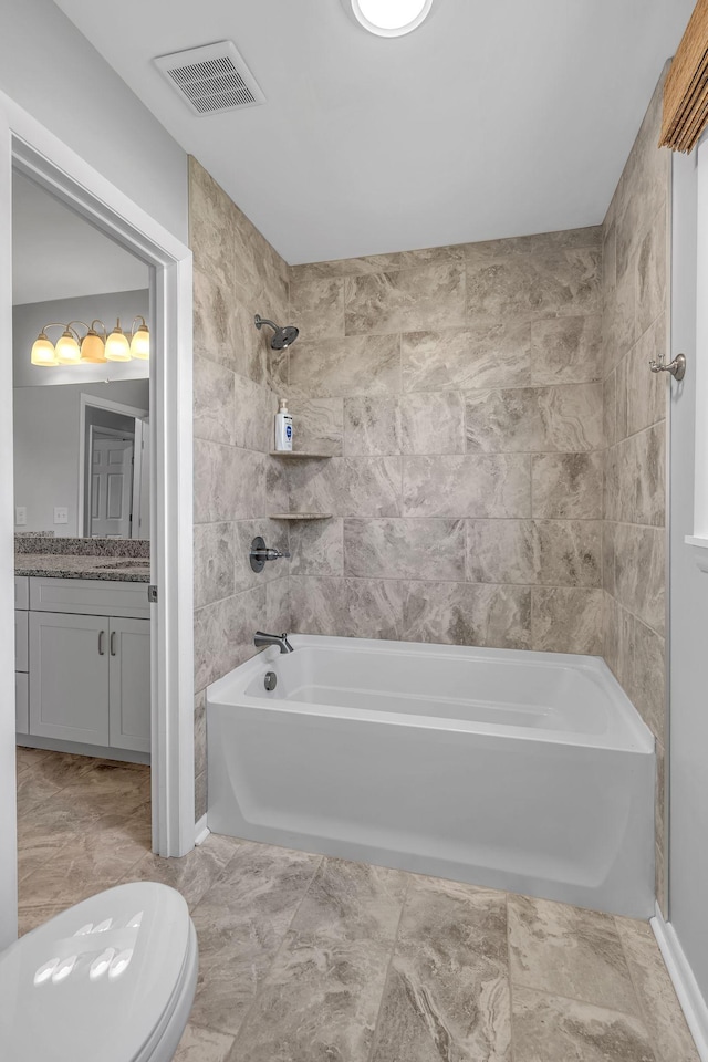 full bathroom featuring toilet, vanity, and tiled shower / bath